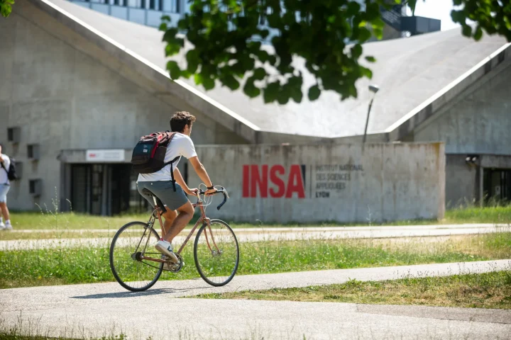 Un étudiant à vélo sur le campus
